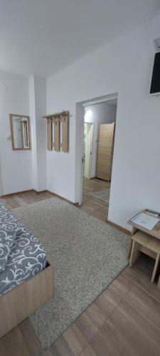 a bedroom with a bed and a table in a room at Sîrbu Orsova in Orşova