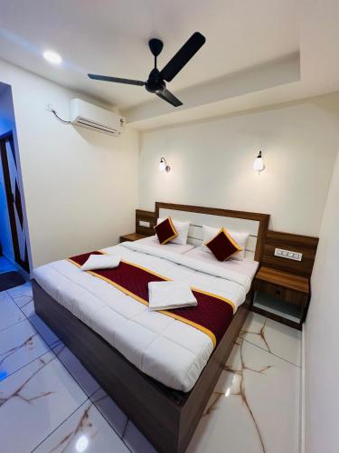 a bedroom with a large bed with a ceiling fan at Shanthi Tourist Home in Pathanāmthitta