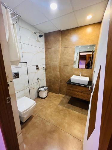 a bathroom with a toilet and a sink and a mirror at Shanthi Tourist Home in Pathanāmthitta