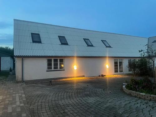 a white building with lights on the side of it at Birkemosegaard in Vedskølle