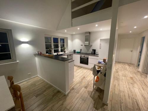 a kitchen with white cabinets and a wooden floor at Birkemosegaard in Vedskølle