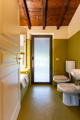 a bathroom with two toilets and a door at Corte Bioti in Pescantina