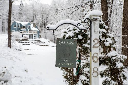 un cartel en la nieve junto a una casa en Vermont Ski Home Lake Home, en Jacksonville