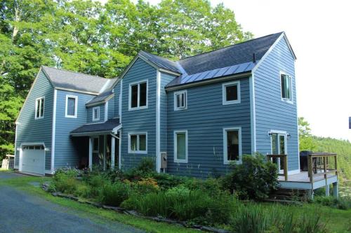 una casa azul con techo de gambrel en Vermont Ski Home Lake Home, en Jacksonville
