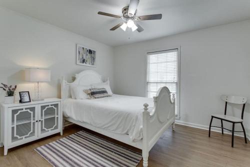une chambre blanche avec un lit et un ventilateur de plafond dans l'établissement Sunset Cottage 2 bed 1 bath Pet-Friendly, à Murfreesboro