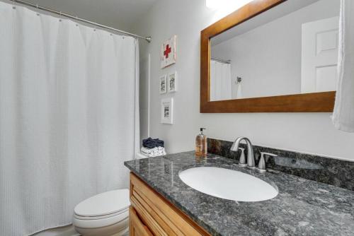 une salle de bain avec un lavabo, des toilettes et un miroir dans l'établissement Sunset Cottage 2 bed 1 bath Pet-Friendly, à Murfreesboro