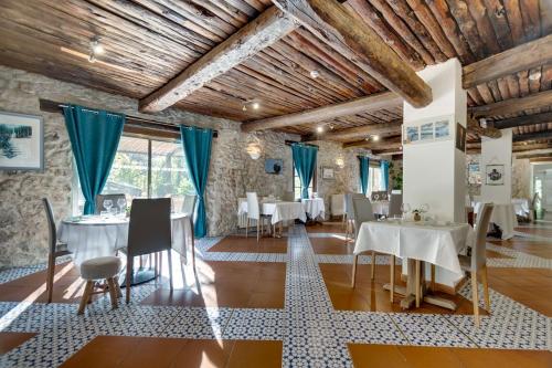 a dining room with white tables and chairs at La Bastide de Montferrat in Montferrat