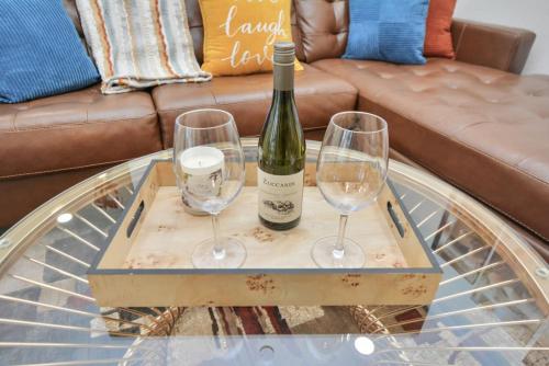a bottle of wine and two wine glasses on a table at Family Fun Oasis Pool Hot Tub and Play Area in Houston