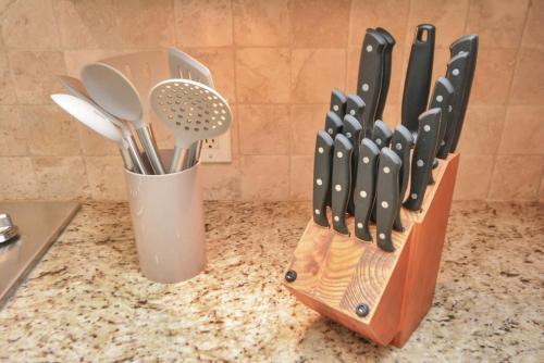 a knife block filled with utensils on a counter at Family Fun Oasis Pool Hot Tub and Play Area in Houston