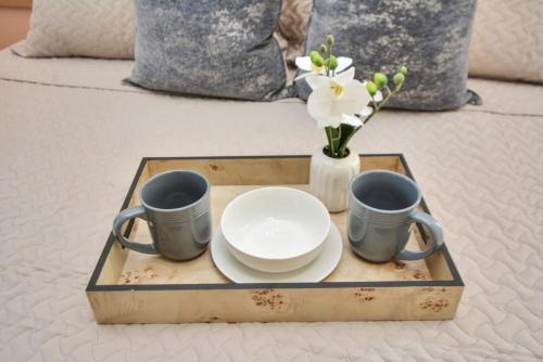 a tray with plates and cups and a vase with flowers at Family Fun Oasis Pool Hot Tub and Play Area in Houston