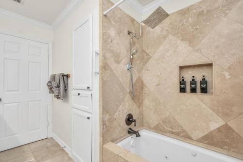 a bathroom with a shower with a bath tub at Family Fun Oasis Pool Hot Tub and Play Area in Houston
