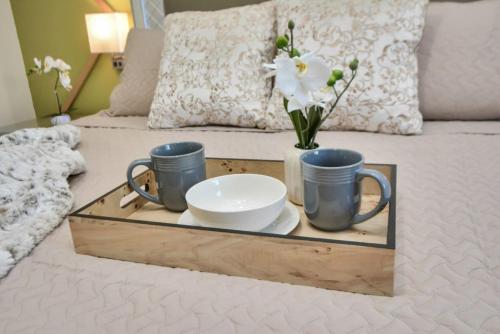 a tray with cups and plates and flowers on a bed at Family Fun Oasis Pool Hot Tub and Play Area in Houston