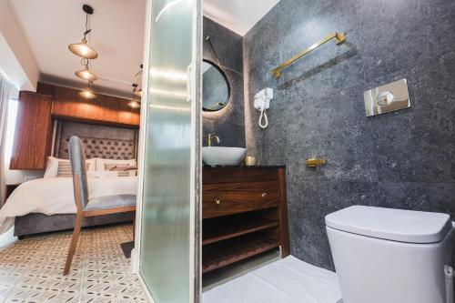 a bathroom with a toilet and a sink and a bed at Zebbuga The Penthouse Suite 7 in Żebbuġ