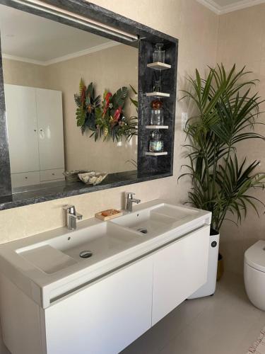 a bathroom with a white sink and a mirror at Quinta da Morgadinha House in Vila Franca do Rosário