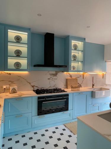 a kitchen with blue cabinets and a stove at Quinta da Morgadinha House in Vila Franca do Rosário