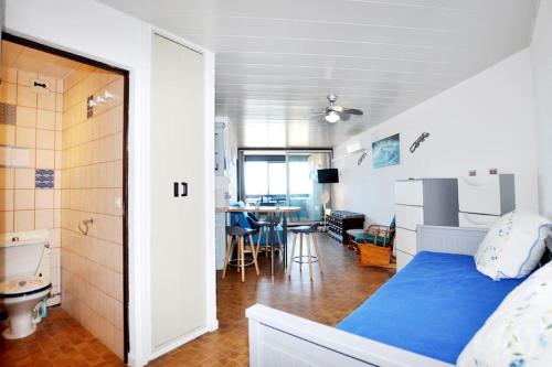 - une chambre avec un lit bleu et une table dans l'établissement Vue mer au Barcarès - Marché de Noël à pied, au Barcarès