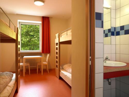 um quarto com beliches, um lavatório e uma mesa em Youth Hostel Luxembourg City no Luxemburgo