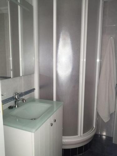 a white bathroom with a sink and a shower at Mi pisito La Maña in San Fernando