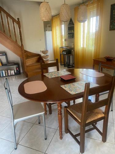 une table et des chaises en bois dans un salon dans l'établissement maison climatisée 2 chambres garage wifi de 1 a 5 voyageurs, à Montfort-le-Gesnois