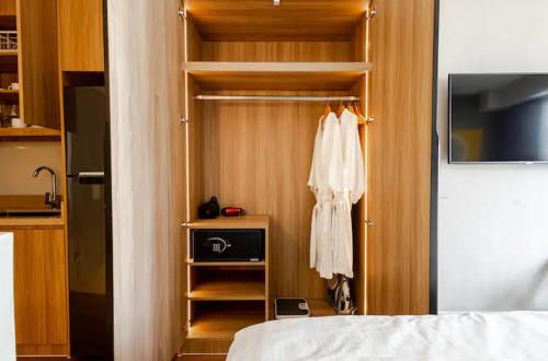 a bedroom with a closet with a robe and a bed at Novotel Suites Manila Aqua Residences Near Makati by Hamodi'sCrib in Manila