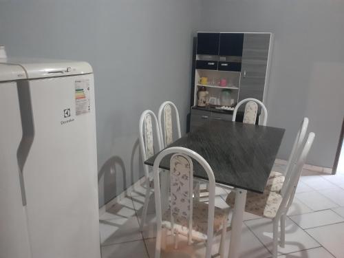 a kitchen with a table and chairs and a refrigerator at Casa do cuscuz in Lençóis