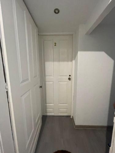 an empty hallway with a white door and wooden floors at Guesthouse Franco in Porto