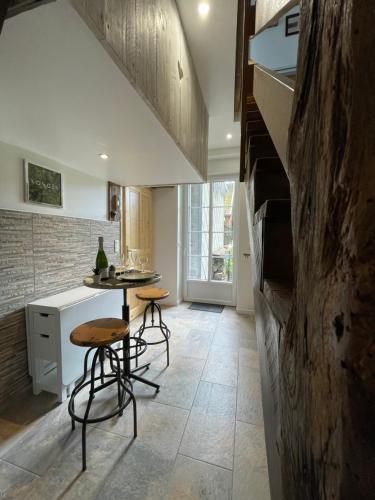 une cuisine avec une table et des tabourets dans une pièce dans l'établissement Appartement lac et montagne, à Gérardmer