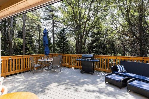 a deck with a table and chairs and an umbrella at One With Nature in Crest Park