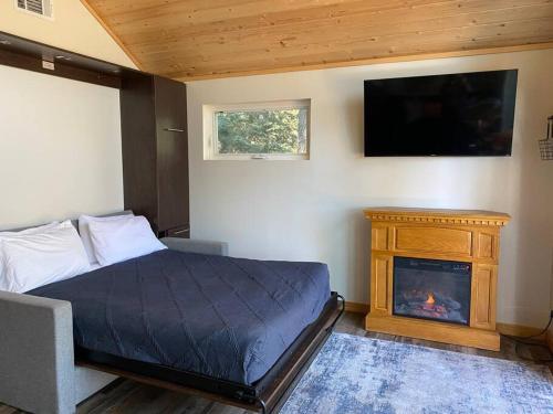 a bedroom with a bed with a fireplace and a flat screen tv at One With Nature in Crest Park
