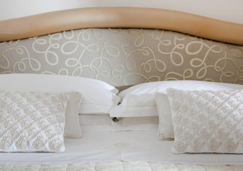 a white bed with white pillows on top of it at La Medusa Hotel - Dimora di Charme in Castellammare di Stabia