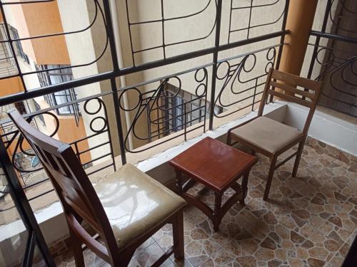 two chairs and a table on a balcony at Evergreen Kile homes in Nairobi