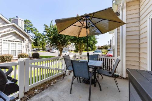 a table and chair with an umbrella on a porch at Fairway Oaks Unit 57B in Myrtle Beach