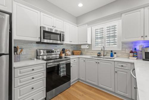 a kitchen with white cabinets and a black stove top oven at Fairway Oaks Unit 57B in Myrtle Beach