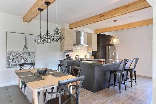 a kitchen and dining room with a table and chairs at Confo27 Chute-Montmorency in Quebec City
