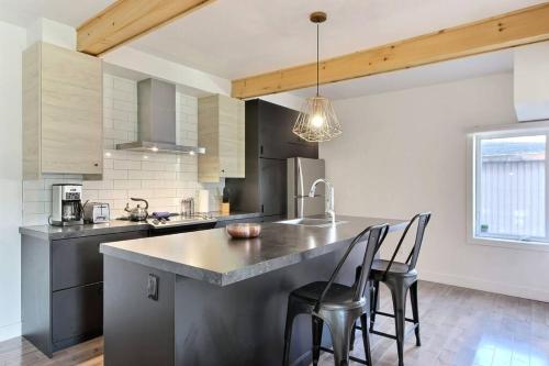 a kitchen with a large counter with chairs in it at Confo27 Chute-Montmorency in Quebec City