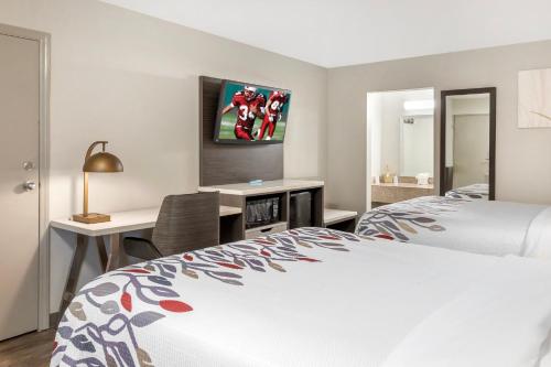 a bedroom with a bed and a desk and a tv at Red Roof Inn Dunn in Dunn