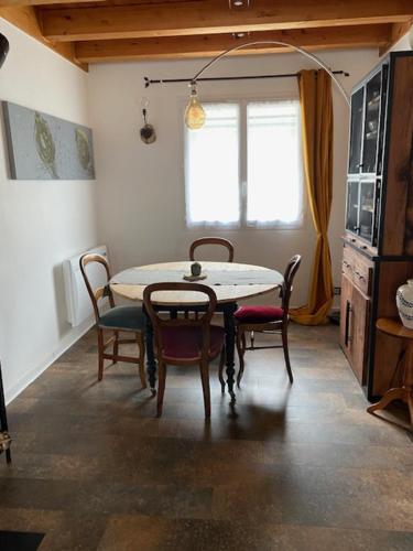 une salle à manger avec une table et des chaises et une fenêtre dans l'établissement Maison individuelle avec piscine entourée de montagnes, à Monthion