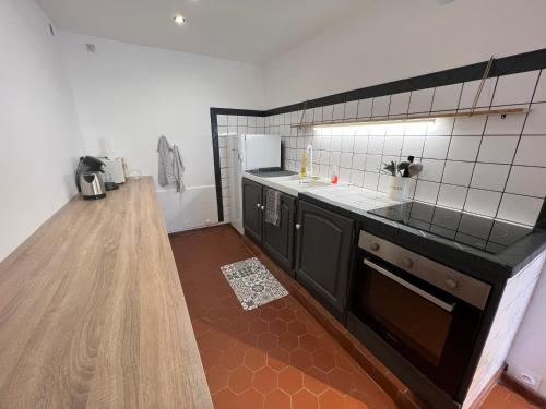 une cuisine avec un évier et un plan de travail dans l'établissement Spacieuse Maison de Village - Baby-foot & Fléchettes, à Saint-Brisson-sur-Loire