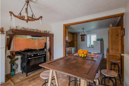 une cuisine avec une table en bois et une salle à manger dans l'établissement Lou Castel, à Le Clapier