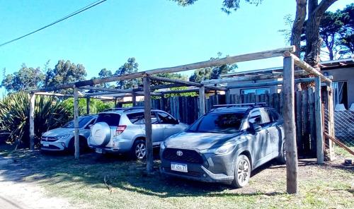 two cars parked next to each other under a shed at Casas del Arroyo in Chapadmalal