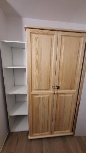 a closet with a wooden door in a room at Appart 4 pers pied des pistes- l'Ecrin-les BERGERS- Chez Lexy in L'Alpe-d'Huez