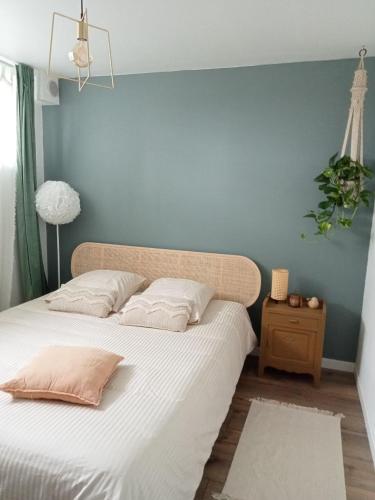 une chambre avec un grand lit avec un mur bleu dans l'établissement Le Rétro de la Gare - FloBNB, à Laon