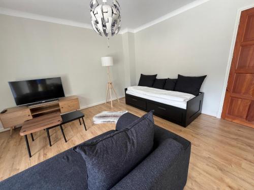 un salon avec un canapé et un lit dans l'établissement Les Balcons du Couloubret, à Ax-les-Thermes