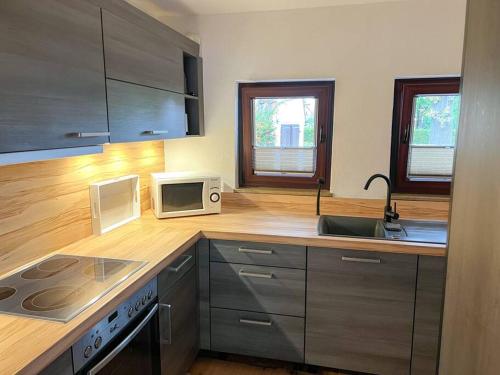 a kitchen with a sink and a microwave at Gemütliches Einfamilienhaus in Espelkamp-Mittwald