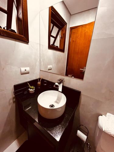 a bathroom with a sink and a mirror at Hospedaria Bicho Preguiça in Sapucaí-Mirim
