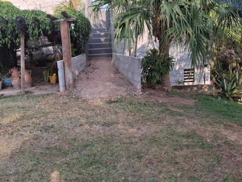 a yard with a fence and palm trees next to a house at Suíte Casa de Luz-Lar na Serra-quarto 03 in Miguel Pereira