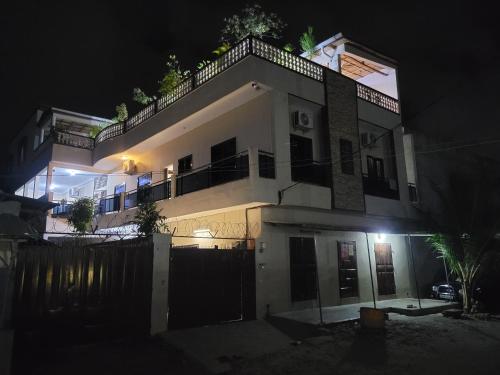 a large white house at night with a fence at Magnifique appartement in Cotonou