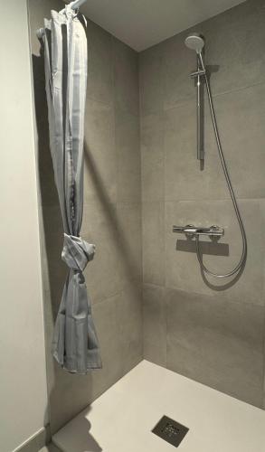 une douche avec un rideau de douche dans une salle de bain dans l'établissement Gîte de la vieille fontaine, à Treize-Vents