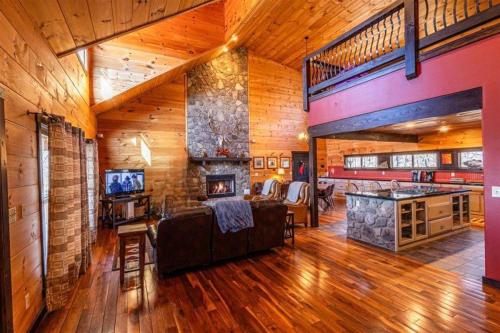 a living room with a large stone fireplace in a house at Sunset Vista in Bryson City