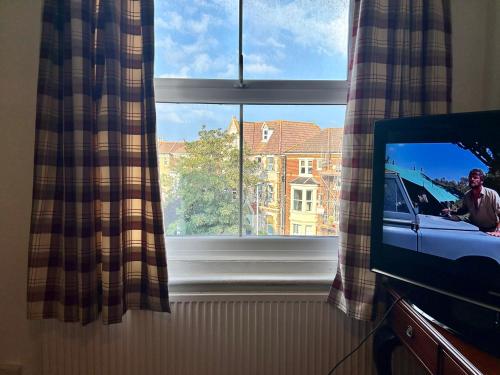 a television in a room with a window at Clarence Quarters Vintage Seafront Guest House in Portsmouth